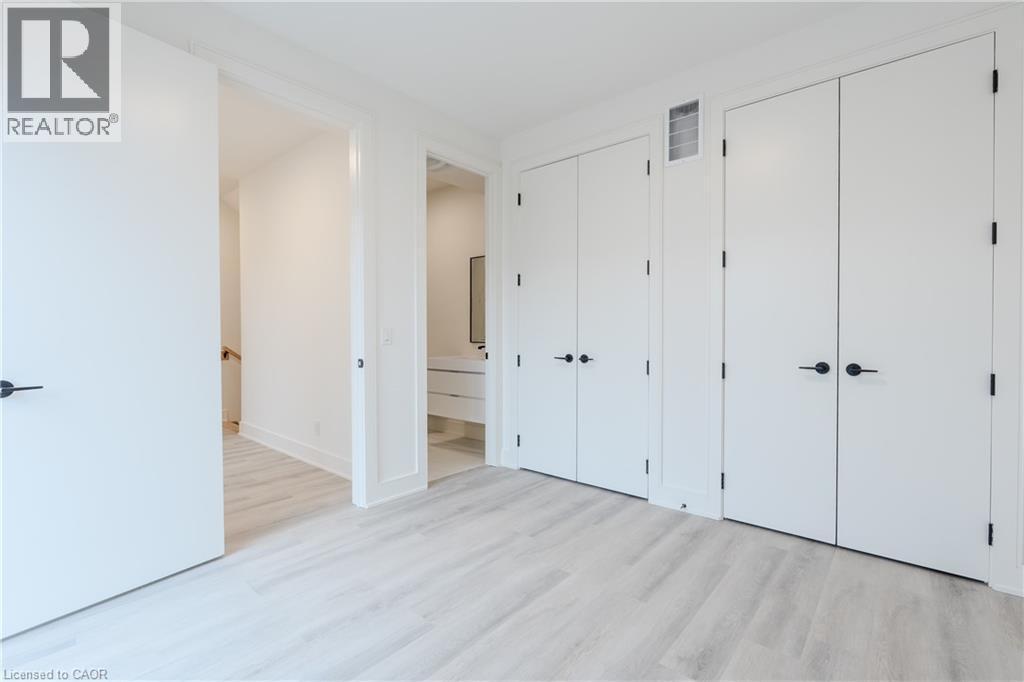 The room features light-toned flooring, white walls, and modern white doors with black hardware - 144 Everett Common, St. Catharines, ON - Indoor Photo Showing Other Room