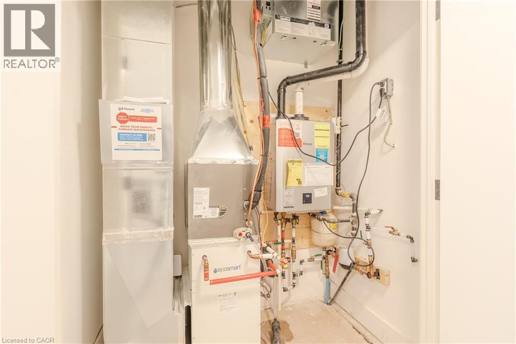 Utility area featuring a water heater, furnace, and exposed piping - 144 Everett Common, St. Catharines, ON - Indoor Photo Showing Other Room