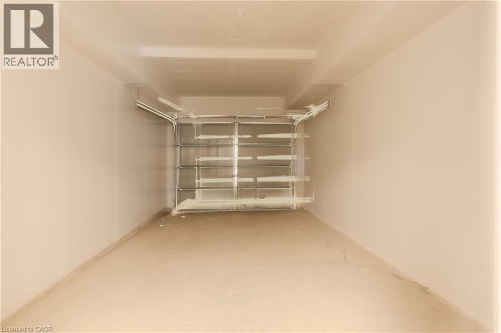 Spacious garage with a concrete floor and a garage door - 144 Everett Common, St. Catharines, ON - Indoor