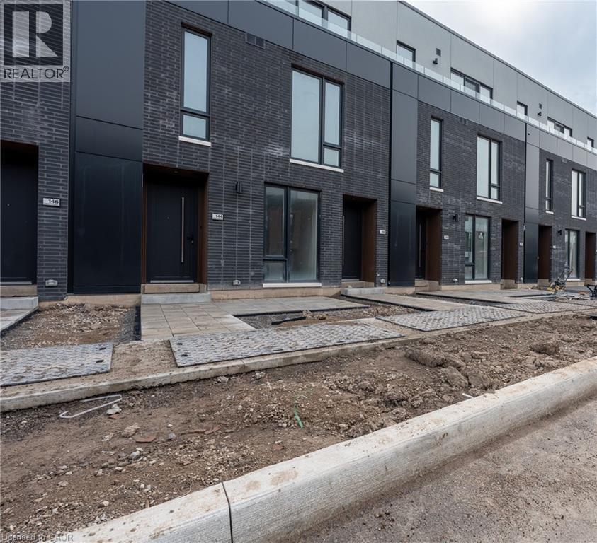 The property features a dark brick exterior with black paneling and tall windows - 144 Everett Common, St. Catharines, ON - Outdoor