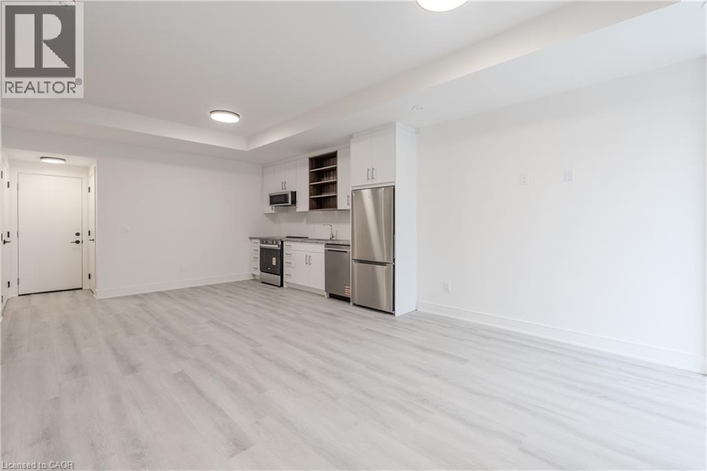 The property features a bright open room with light-toned flooring, white walls, and recessed lighting - 144 Everett Common, St. Catharines, ON - Indoor Photo Showing Kitchen
