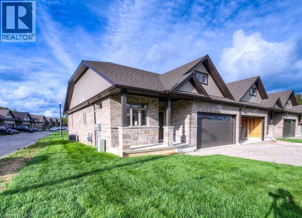 Stone and siding exterior featuring a covered front porch, an attached garage, and a gabled roofline - 48 Main Street E, Innerkip, ON - Outdoor With Deck Patio Veranda