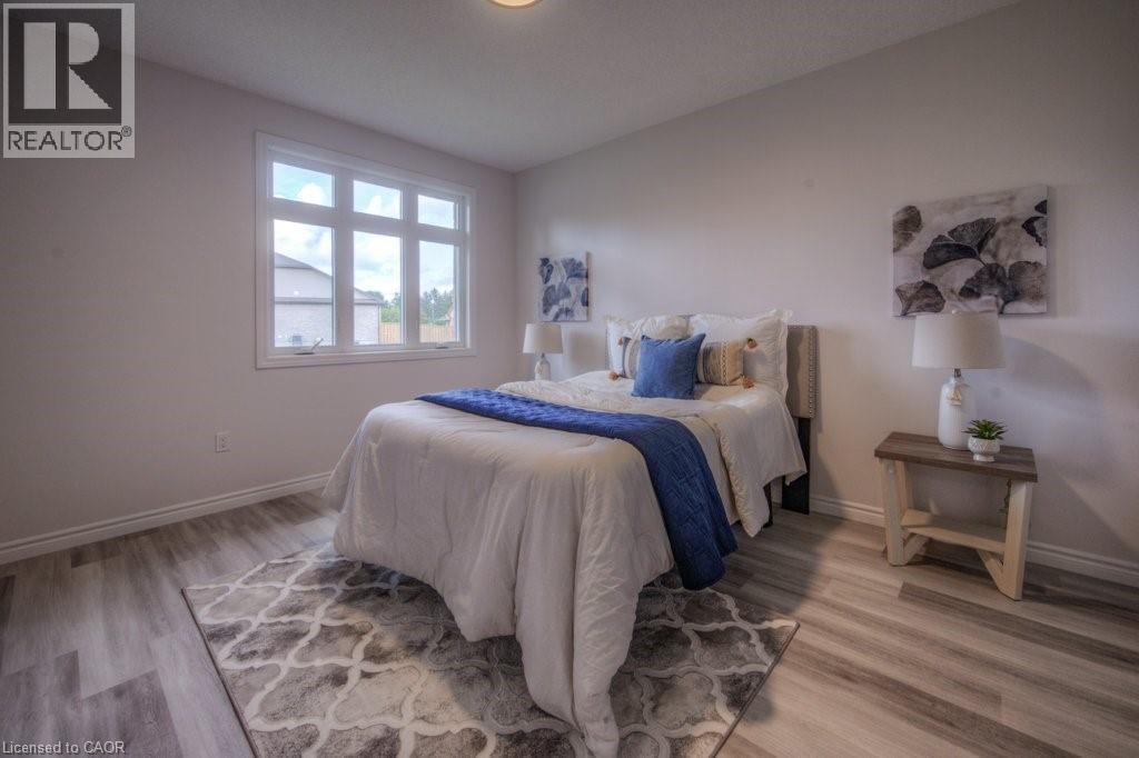 Bright room featuring wood-finish flooring, a large multi-pane window, white baseboards, and a neutral wall color - 48 Main Street E, Innerkip, ON - Indoor Photo Showing Bedroom
