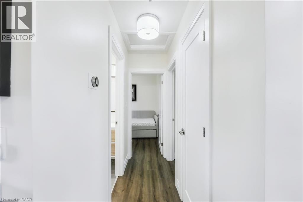 Hallway featuring wood-finish flooring and a contemporary ceiling light fixture - 18 Tweedsmuir Avenue, London, ON - Indoor Photo Showing Other Room