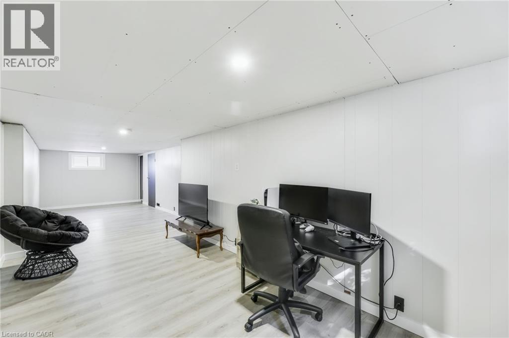 Spacious room featuring light wood-finish flooring, white paneled walls, recessed lighting, and a white ceiling - 18 Tweedsmuir Avenue, London, ON - Indoor