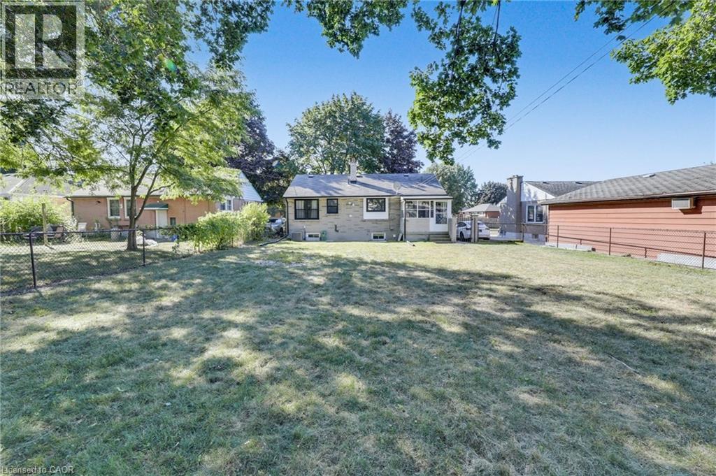 Expansive grassy yard with mature trees providing partial shade - 18 Tweedsmuir Avenue, London, ON - Outdoor