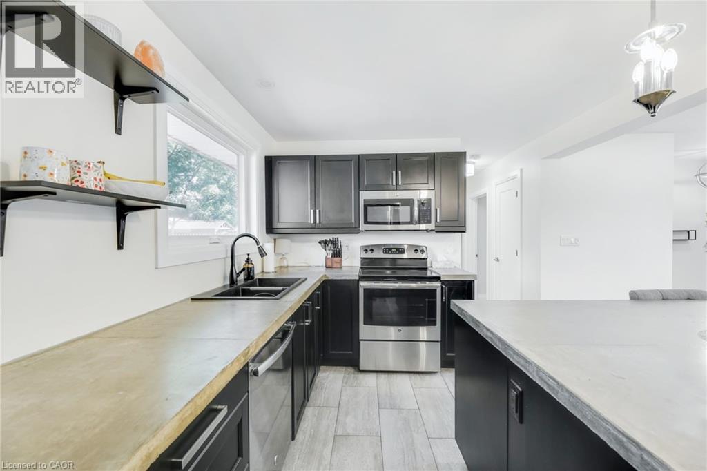 Kitchen with light-toned countertops, black cabinetry, and stainless steel appliances - 18 Tweedsmuir Avenue, London, ON - Indoor Photo Showing Kitchen With Stainless Steel Kitchen With Double Sink