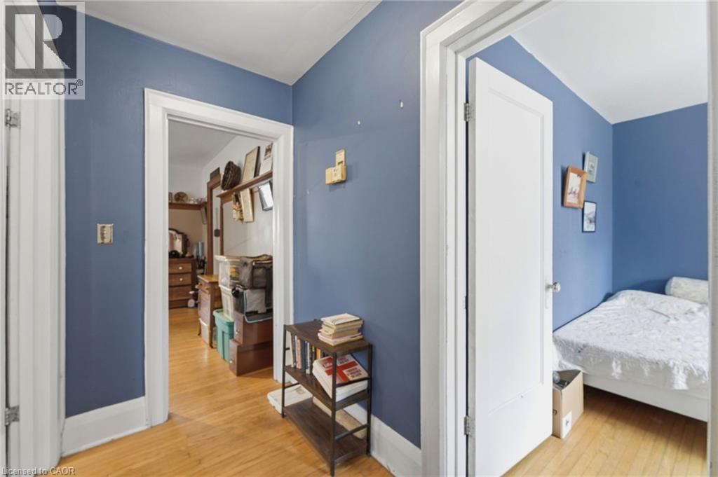 Hallway with wood-finish flooring, blue painted walls, and white trim - 509 Aberdeen Avenue, Hamilton, ON - Indoor