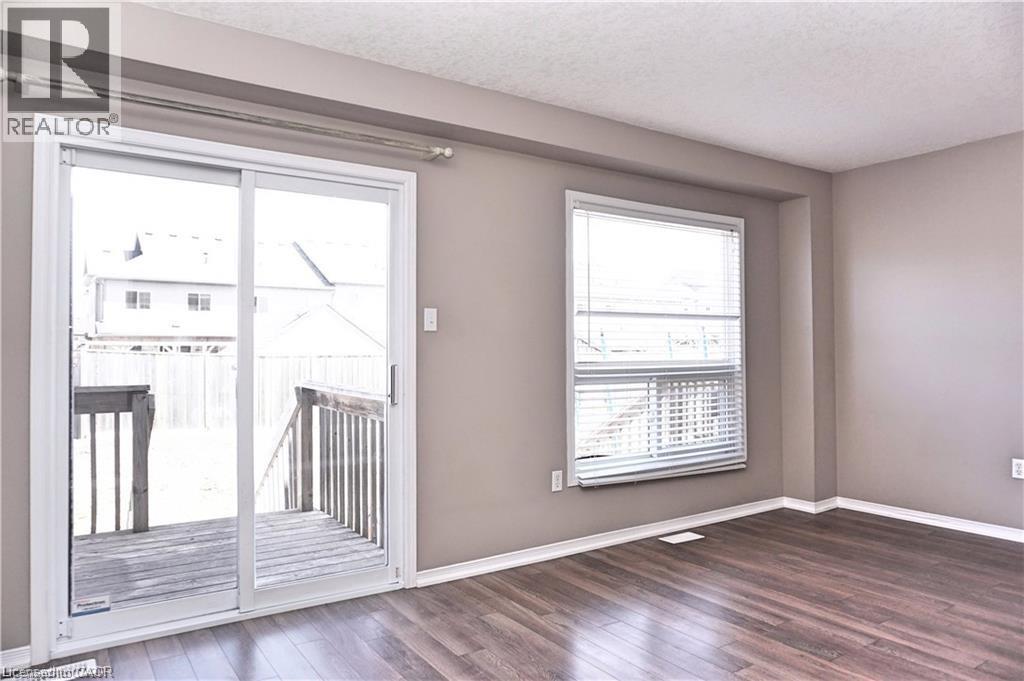 Interior space featuring wood-finish flooring, neutral wall tones, and white baseboards - 40 Madeleine Street, Kitchener, ON