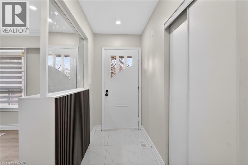 Foyer featuring a white front door with decorative glass inserts, recessed lighting, and large format tile flooring - 53 Nicklin Crescent, Guelph, ON - Indoor Photo Showing Other Room
