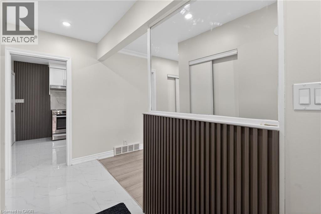Modern interior featuring a wood-slat half-wall with a glass panel, recessed ceiling lighting, and light-colored walls - 53 Nicklin Crescent, Guelph, ON - Indoor Photo Showing Other Room