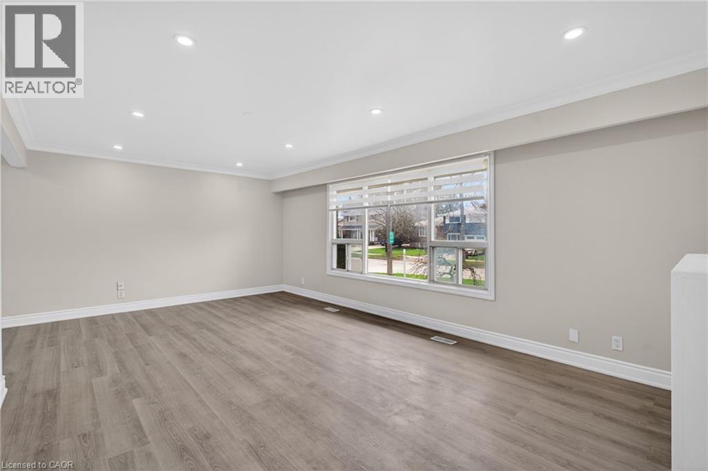 Spacious room featuring wood-finish flooring, recessed lighting, and crown molding - 53 Nicklin Crescent, Guelph, ON - Indoor