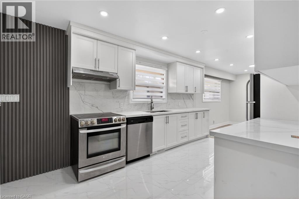Modern kitchen featuring white cabinetry, stainless steel appliances, a marble-patterned backsplash, white quartz countertops, and recessed lighting - 53 Nicklin Crescent, Guelph, ON - Indoor Photo Showing Kitchen With Stainless Steel Kitchen