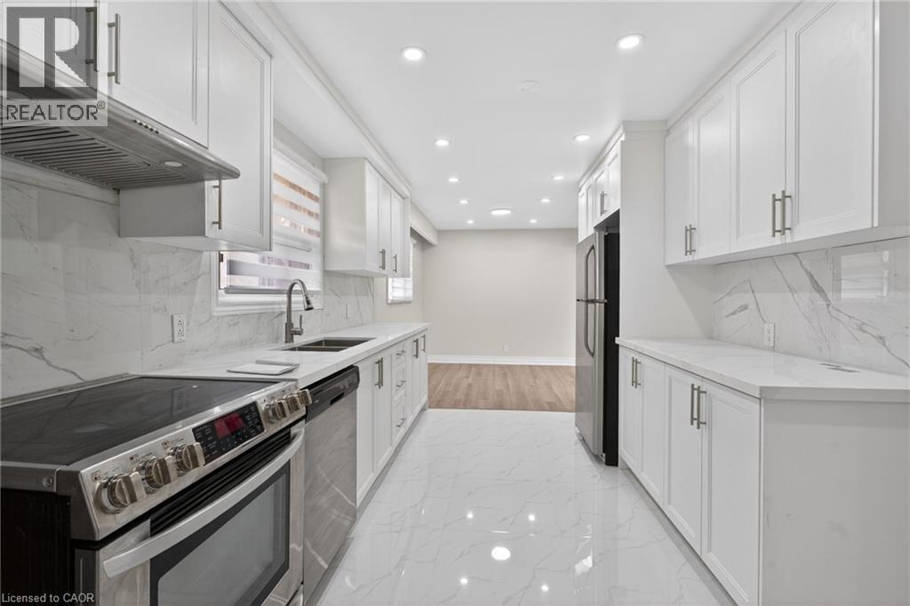 Modern kitchen featuring white shaker cabinetry, stainless steel appliances, white countertops, and a white marble-patterned backsplash - 53 Nicklin Crescent, Guelph, ON - Indoor Photo Showing Kitchen With Stainless Steel Kitchen With Double Sink With Upgraded Kitchen