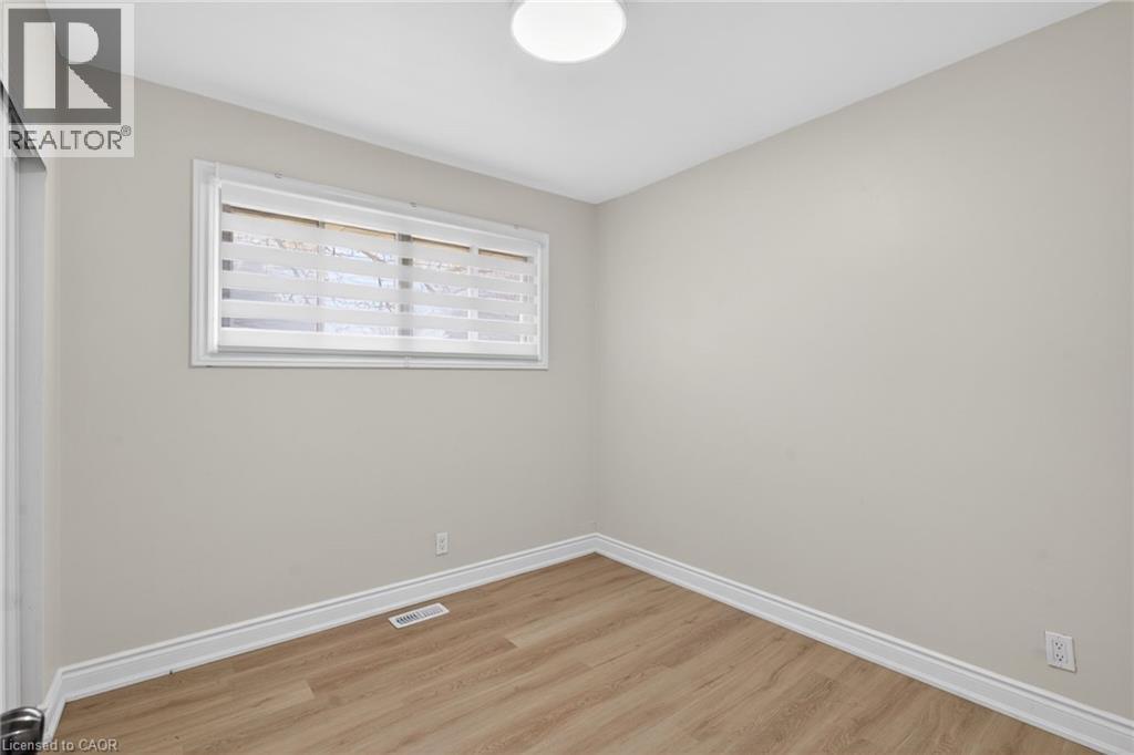 Neutral wall paint, wood-finish flooring, and white trim - 53 Nicklin Crescent, Guelph, ON - Indoor Photo Showing Other Room