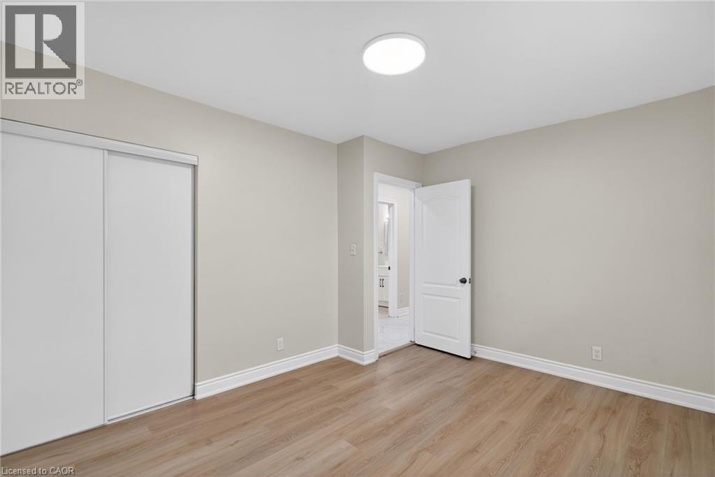 Neutral-toned room featuring light wood-finish flooring, white baseboards, and a contemporary ceiling light fixture - 53 Nicklin Crescent, Guelph, ON - Indoor Photo Showing Other Room