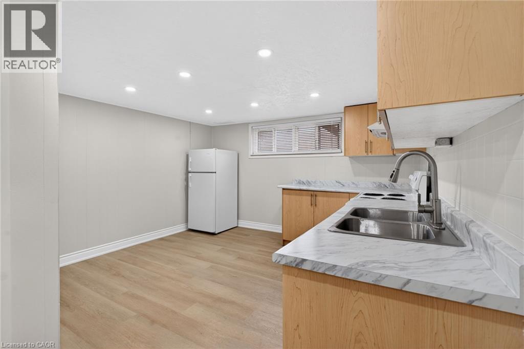 Kitchen area featuring wood-finish flooring, recessed lighting, and a window with blinds - 53 Nicklin Crescent, Guelph, ON - Indoor Photo Showing Kitchen With Double Sink