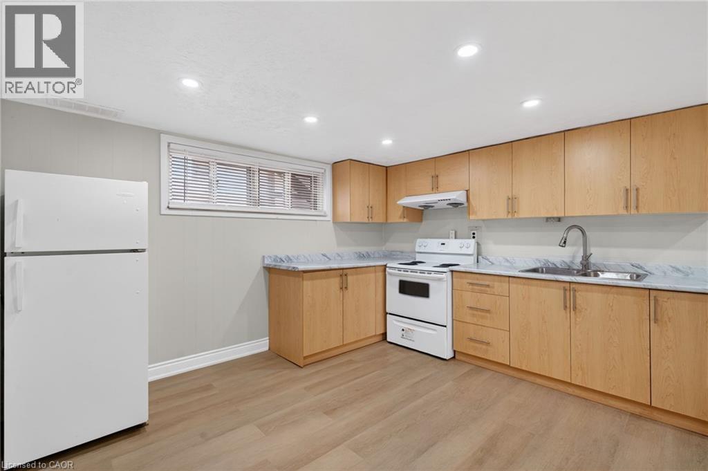 Kitchen featuring light wood-finish cabinetry, white appliances, and marble-look countertops - 53 Nicklin Crescent, Guelph, ON - Indoor Photo Showing Kitchen With Double Sink