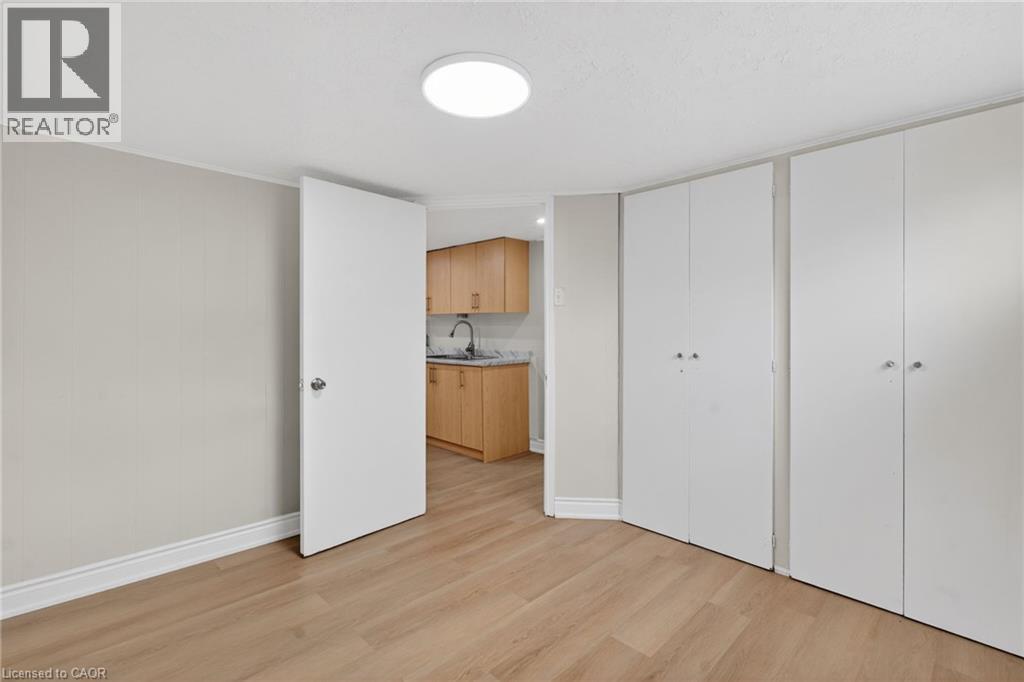 Light wood-finish flooring extending into the kitchen area - 53 Nicklin Crescent, Guelph, ON - Indoor