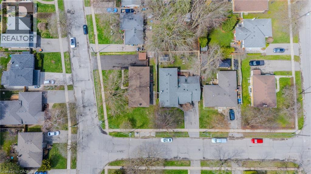 Aerial view of a residential corner lot property featuring an asphalt driveway and a detached dwelling with a dark shingle roof - 53 Nicklin Crescent, Guelph, ON - With View