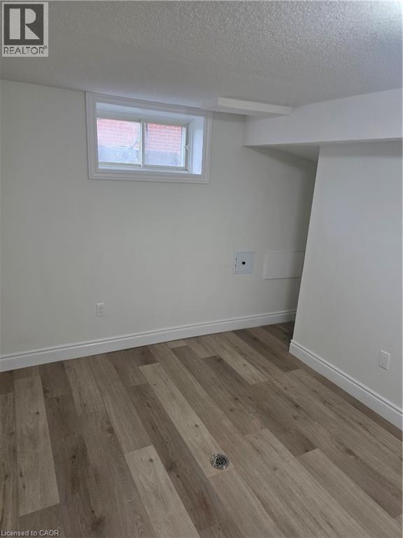 Room featuring wood-finish flooring, white baseboards, and a window with white trim - 22 Montrose Avenue, Kitchener, ON - Indoor Photo Showing Other Room