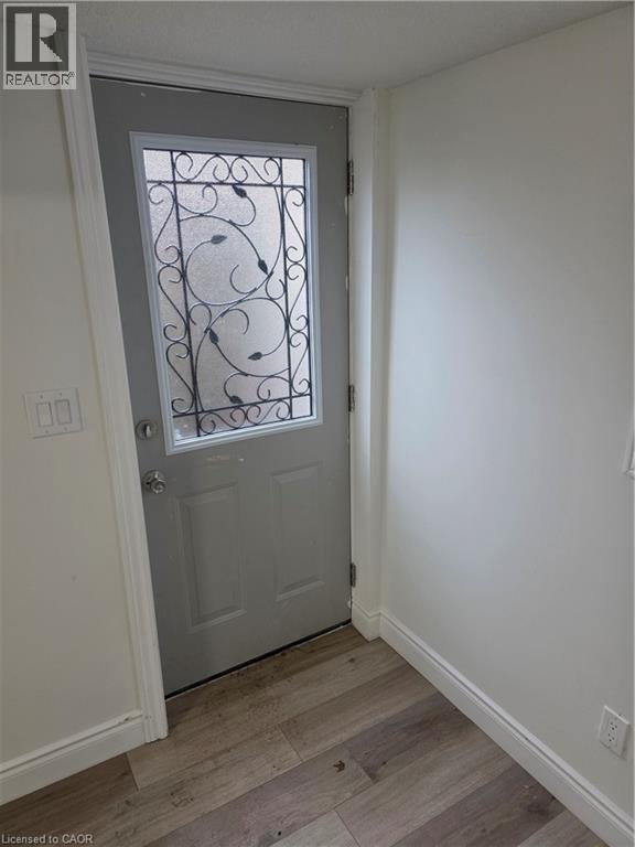 Entry door featuring decorative wrought iron scrollwork over frosted glass - 22 Montrose Avenue, Kitchener, ON - Indoor Photo Showing Other Room