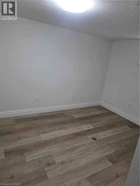 Room featuring wood-finish flooring, white baseboards, and neutral wall paint - 22 Montrose Avenue, Kitchener, ON - Indoor Photo Showing Other Room