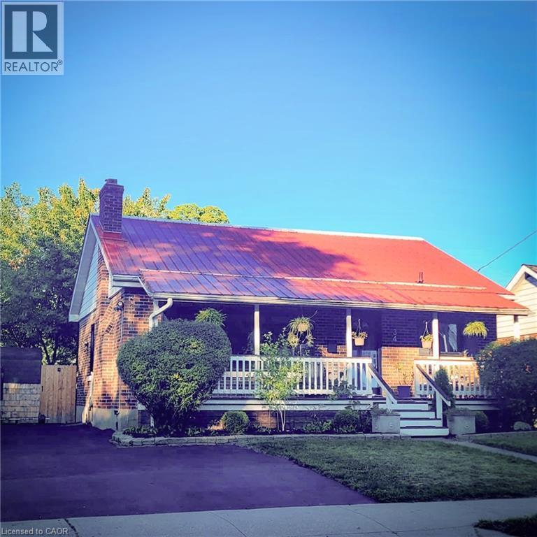 Brick exterior with a prominent red metal roof - 34 Christopher Drive, Cambridge, ON - Outdoor With Deck Patio Veranda