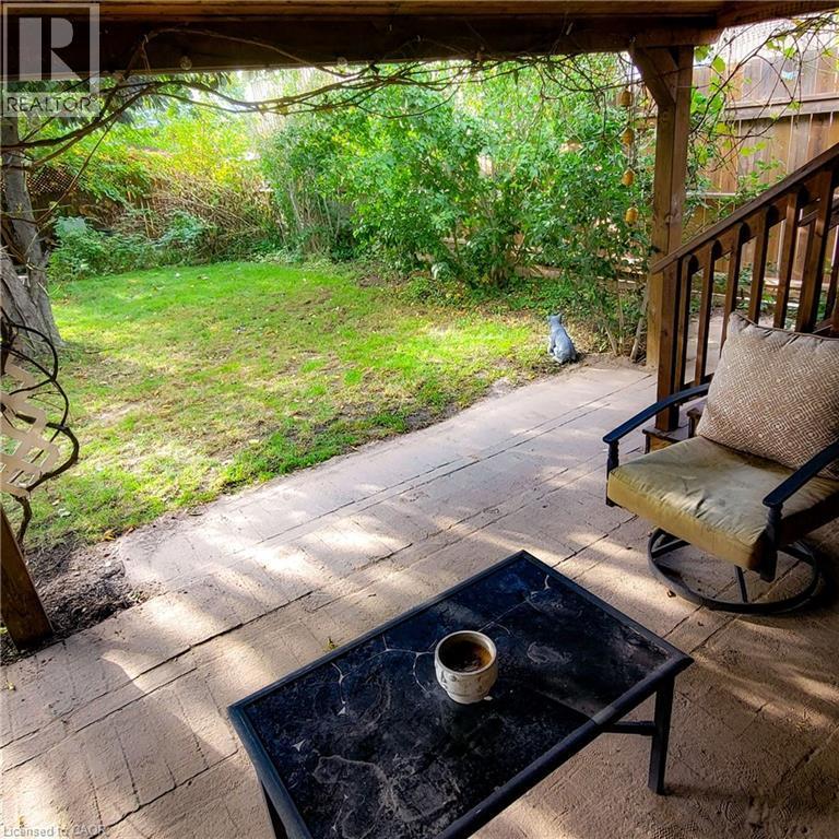 Covered outdoor patio with wood-finish flooring and a partial wood railing - 34 Christopher Drive, Cambridge, ON - Outdoor
