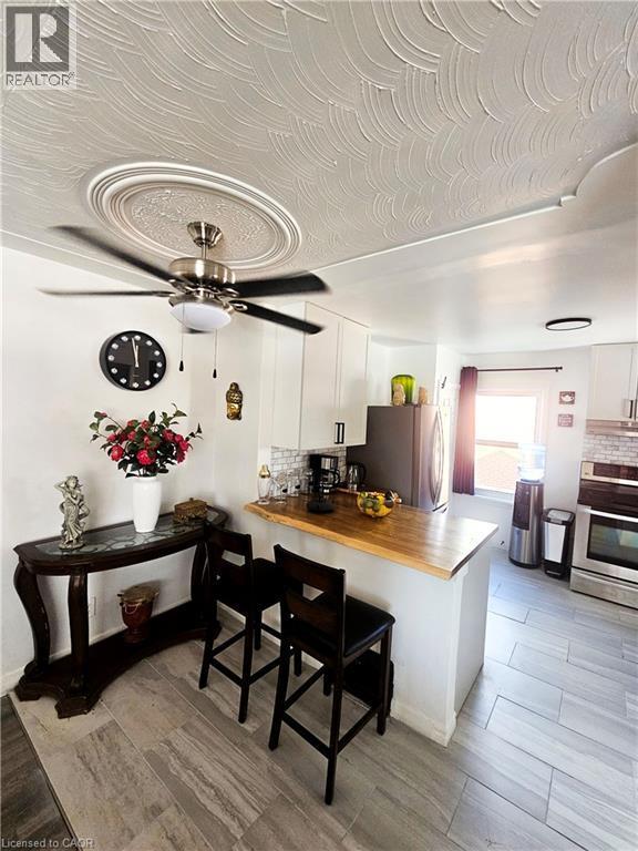 Kitchen area featuring light wood-finish flooring and a breakfast bar with a wood countertop - 34 Christopher Drive, Cambridge, ON - Indoor Photo Showing Other Room
