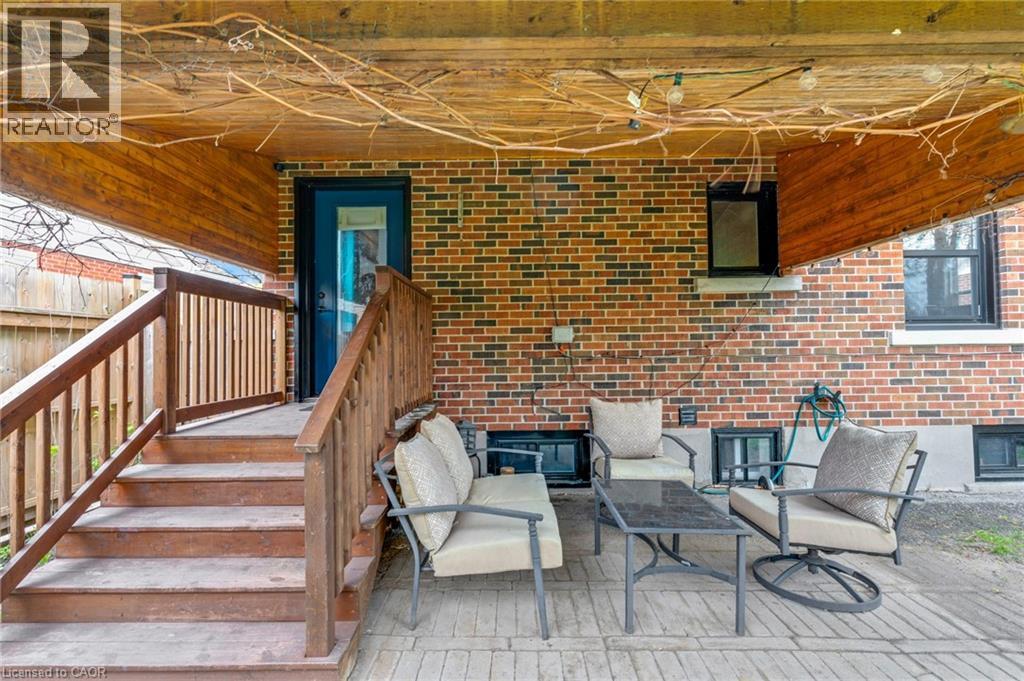 Covered patio featuring a wooden ceiling, brick exterior, and wood-finish steps with railings - 34 Christopher Drive, Cambridge, ON - Outdoor With Deck Patio Veranda With Exterior