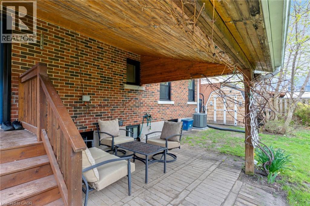 Covered brick patio featuring paver flooring, a wood-paneled ceiling, and direct access to a grassy yard - 34 Christopher Drive, Cambridge, ON - Outdoor With Deck Patio Veranda With Exterior