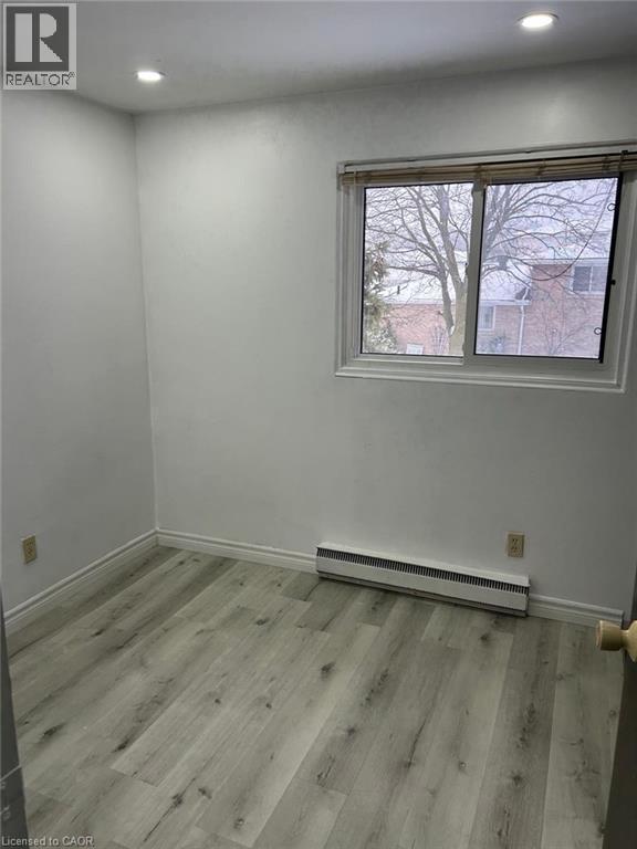 Bright room with wood-finish flooring, white baseboards, and a window with blinds - 744 Parkview Crescent, Cambridge, ON - Indoor Photo Showing Other Room