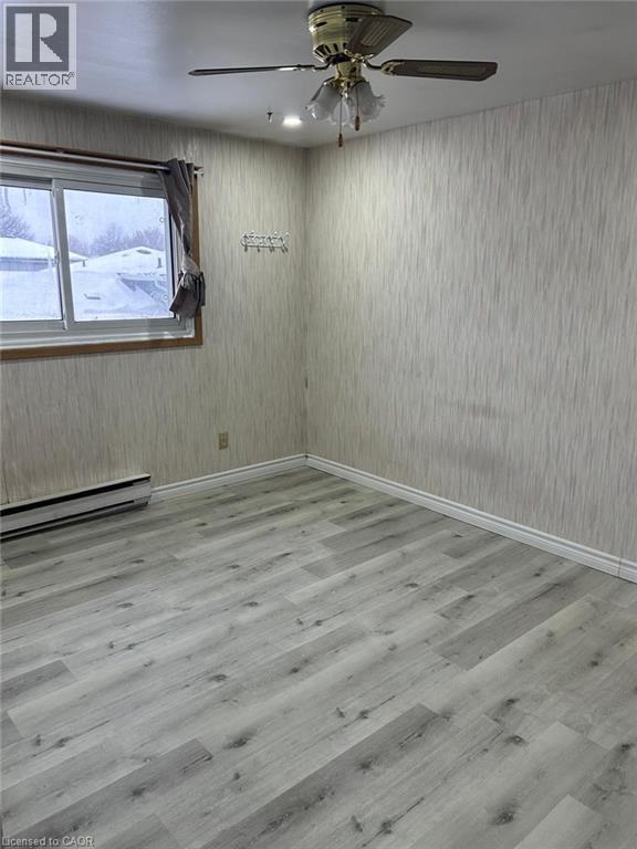 Interior room featuring wood-finish flooring, a ceiling fan with light fixture, and vertical striped wallpaper - 744 Parkview Crescent, Cambridge, ON - Indoor Photo Showing Other Room