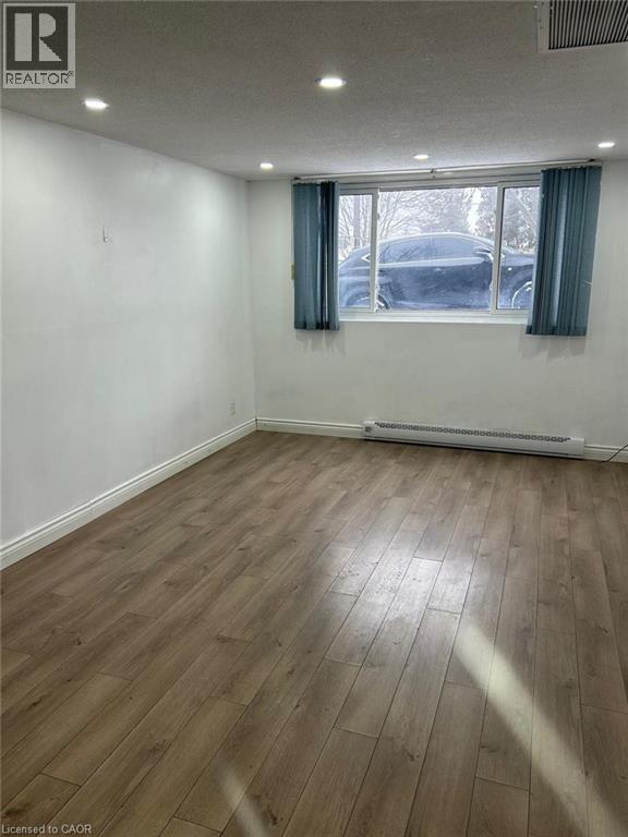 Room featuring wood-finish flooring, white baseboards, and neutral wall tones - 744 Parkview Crescent, Cambridge, ON - Indoor Photo Showing Other Room