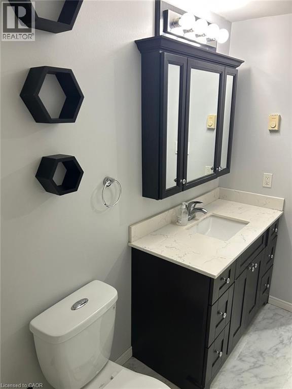 Bathroom featuring a dark wood-finish vanity with a light-colored countertop, an undermount sink, and a mirrored medicine cabinet - 744 Parkview Crescent, Cambridge, ON - Indoor Photo Showing Bathroom