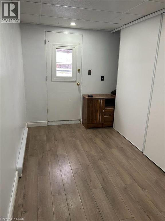 Interior space featuring wood-finish flooring, white walls, and a white door with a window pane - 744 Parkview Crescent, Cambridge, ON - Indoor Photo Showing Other Room