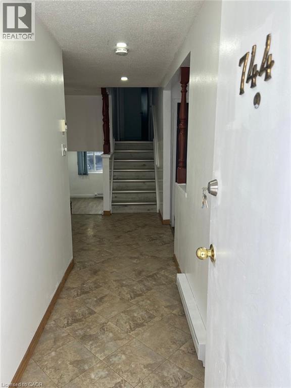Foyer featuring patterned tile flooring, white walls, wood baseboards, and a view to an internal staircase with wood newel posts - 744 Parkview Crescent, Cambridge, ON - Indoor Photo Showing Other Room
