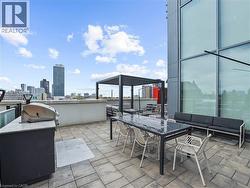 Spacious rooftop patio featuring paver flooring, a built-in outdoor kitchen with a grill, and a modern pergola structure -
