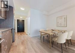 Expansive wood-finish flooring extends throughout the space, complementing the dark wood-grain cabinetry and light countertops -