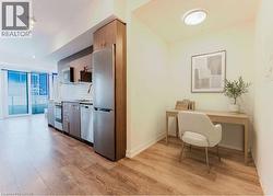 Open-concept living space with wood-finish flooring, a contemporary kitchen, and a dedicated alcove -