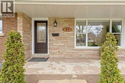Front facade featuring a dark paneled entry door with decorative glass, stacked stone veneer, and a brick accent wall - 