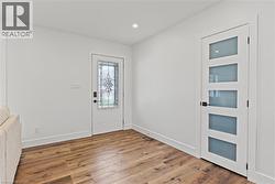 Entryway featuring wood-finish flooring, white walls, and a recessed ceiling light - 