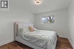 Room featuring wood-finish flooring, white baseboards, and neutral wall paint - 