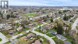 Aerial perspective showcasing residential neighborhood streets, surrounding green spaces, and a distant water tower - 