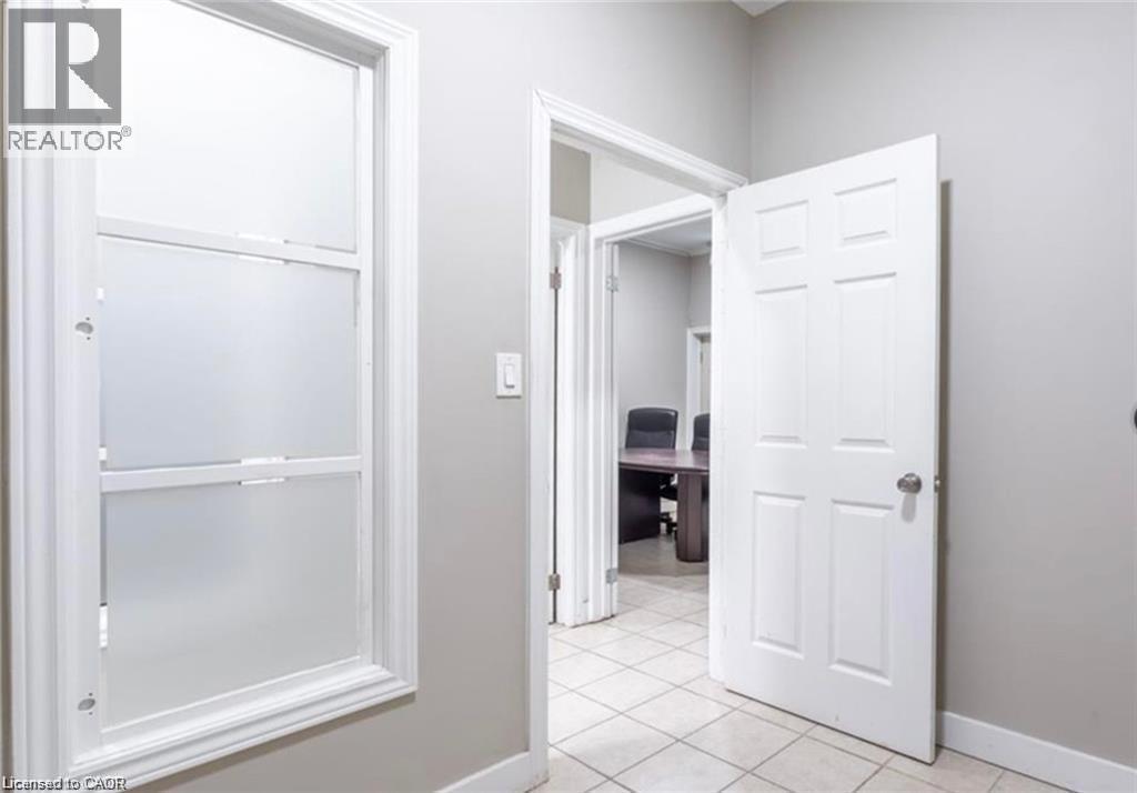 The interior features light-colored walls, white trim, and a window with frosted panes - 833 King Street E, Hamilton, ON
