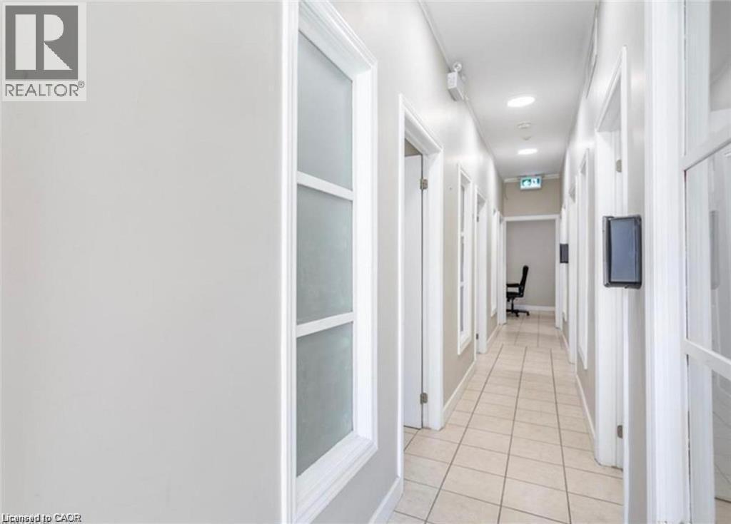 The property features a hallway with light-colored tile flooring and white walls - 833 King Street E, Hamilton, ON