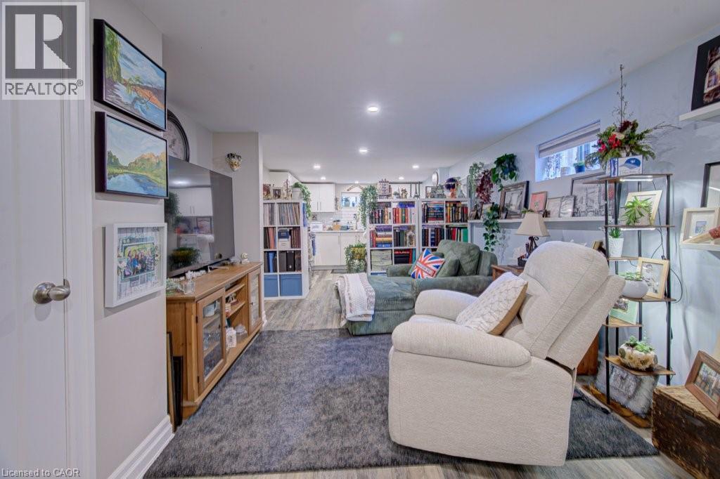 Spacious room featuring wood-finish flooring, recessed lighting, and a neutral color palette - 1486 Augustine Drive, Burlington, ON - Indoor