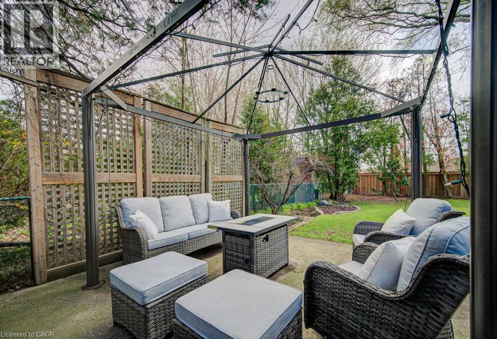 Expansive patio featuring a metal gazebo frame, concrete flooring, and surrounding wooden lattice privacy screens - 1486 Augustine Drive, Burlington, ON - Outdoor With Deck Patio Veranda With Exterior