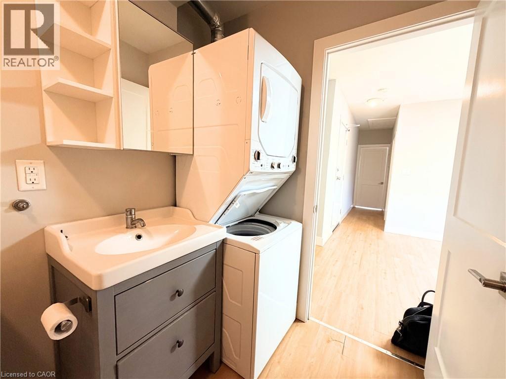 Dedicated laundry area featuring a stacked washer and dryer unit - 310 Barton Street E Unit# A, Hamilton, ON - Indoor Photo Showing Laundry Room